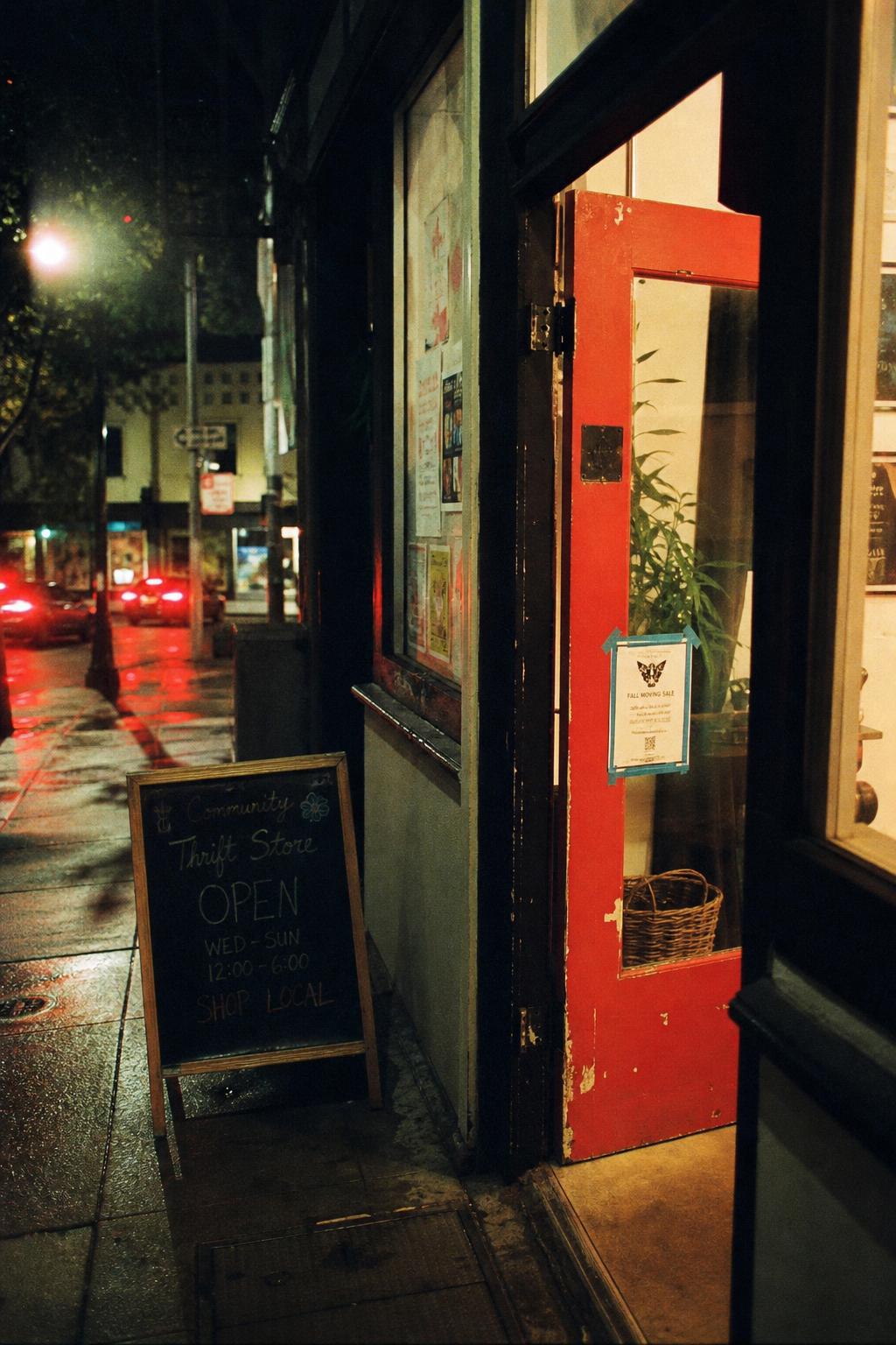 A vermillion red door slightly ajar on a San Francisco street